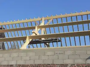 Charpente traditionnelle en bois avec assemblage de poutres apparentes réalisée par un charpentier.