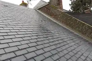 Vue en hauteur d’une toiture en tuiles en cours d’installation, montrant l'alignement soigné des éléments.