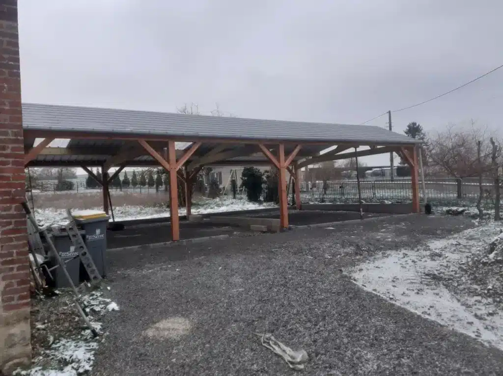 Carport en bois fabriqué par un charpentier pour abriter des véhicules, avec une structure robuste et esthétique. ​​