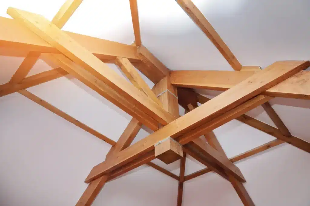 Charpente traditionnelle en bois massif, conçue et assemblée par un charpentier pour un toit de maison, mettant en valeur l'artisanat du bois.